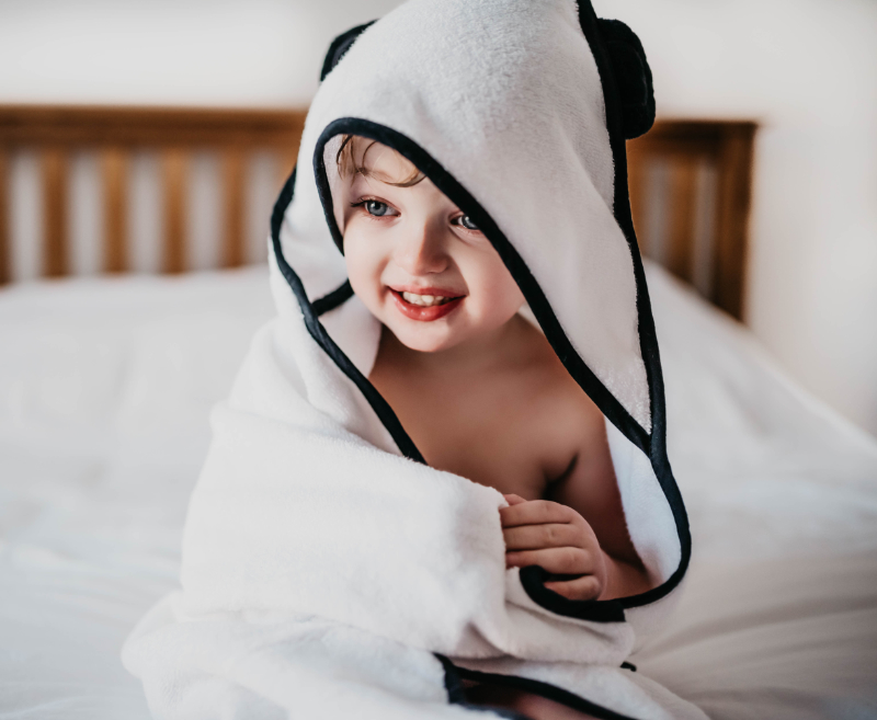 Child Smiling Wearing Panda London 100 Bamboo Hooded Towel In White